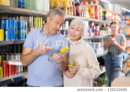Elderly couple choosing refreshing drinks in supermarket 120212686