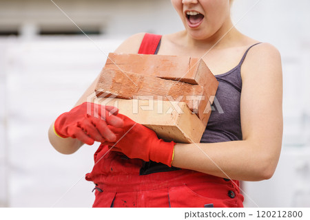 Funny woman carrying heavy bricks Funny woman carrying heavy bricks 120212800