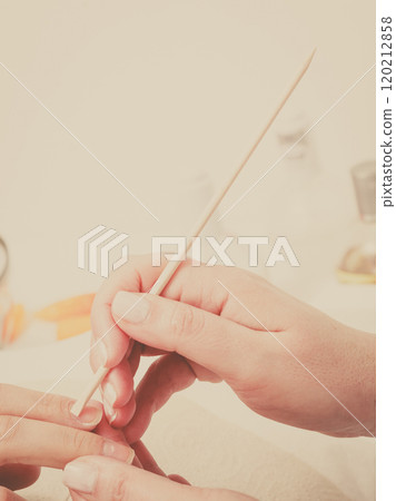 Preparing nails before manicure, pushing back cuticles Preparing nails before manicure, pushing back cuticles 120212858