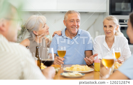 Old men and women talking merrily while having snack in the kitchen 120212874