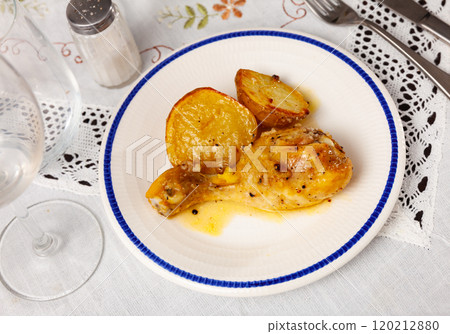 Spicy bbq chicken legs with with boiled potato close-up on plate 120212880
