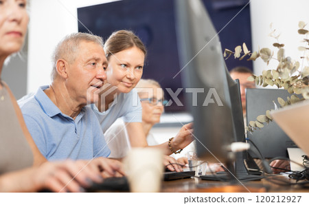 Woman teacher helping elderly people learn how to use computer Woman teacher helping elderly people learn how to use computer 120212927