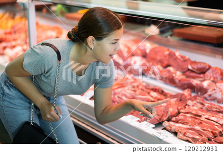Female customer points with finger and orders beef brisket and sirloin Female customer points with finger and orders beef brisket and sirloin 120212931