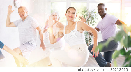 Young teacher and group of positive aged people engaged in dynamic dances Young teacher and group of positive aged people engaged in dynamic dances 120212963