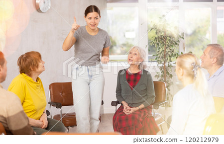 Young female psychologist conducting a group session with mature clients Young female psychologist conducting a group session with mature clients 120212979