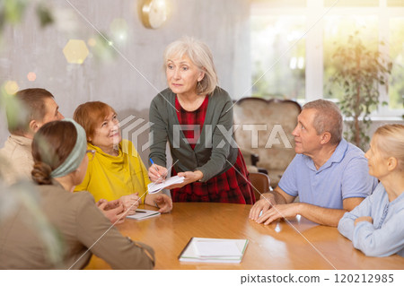 Mature female professor giving lecture to elderly students 120212985