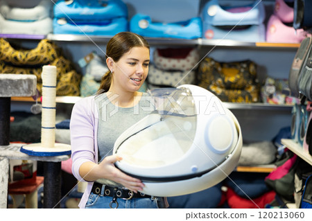 Female dog owner choosing portable carrier in pet shop Female dog owner choosing portable carrier in pet shop 120213060