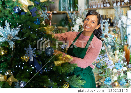 Woman home goods store worker decorating christmas tree 120213145