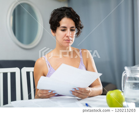 Girl with papers at table working with documents Girl with papers at table working with documents 120213203