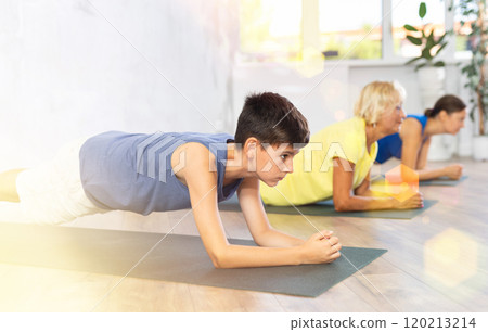 Mother, grandmother and adolescence son do exercise elbow plank pose Sampatasana. 120213214