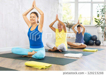Group of people generation on mats doing yoga exercise lord of fishes pose. Group of people generation on mats doing yoga exercise lord of fishes pose. 120213288