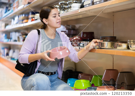 Young woman choosing bowl for puppy in pet supplies store Young woman choosing bowl for puppy in pet supplies store 120213350