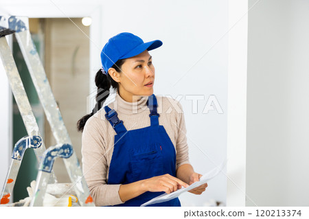Female engineer matching check list during repair works 120213374