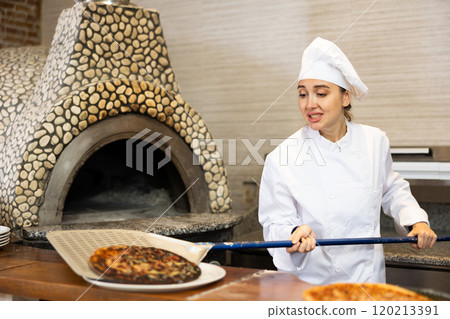 Stressed woman chef preparing pizza in pizzeria 120213391