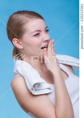 Bored sleepy woman yawning while holding towel Bored sleepy woman yawning while holding towel 120213561