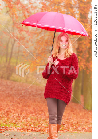 Fashion woman with umbrella relaxing in fall park. 120213595