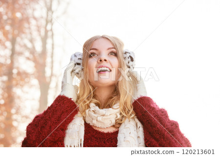 Portrait of pretty smiling woman in earmuffs. Portrait of pretty smiling woman in earmuffs. 120213601