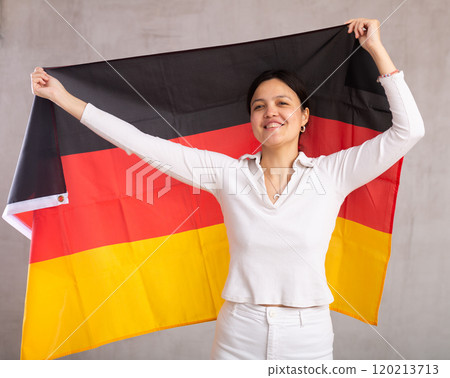 Young woman posing in studio with Germany flag 120213713