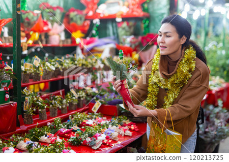 Woman choosing christmas decorations at fair Woman choosing christmas decorations at fair 120213725