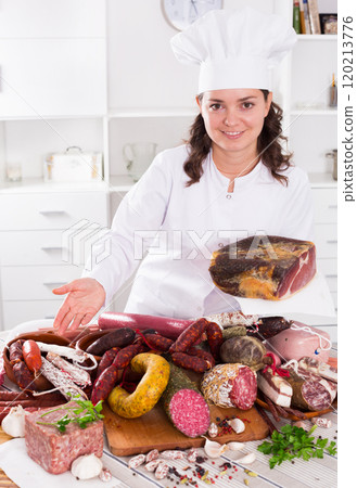 Girl shows sausages and smoked products 120213776