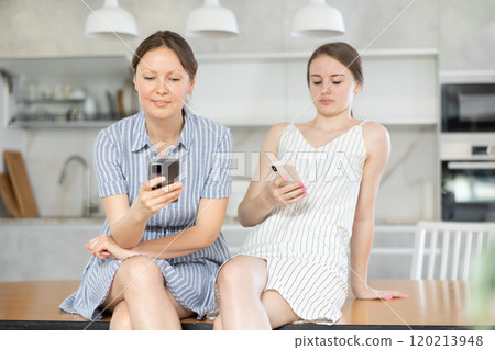 Mom and adult daughter using smartphone in home Mom and adult daughter using smartphone in home 120213948