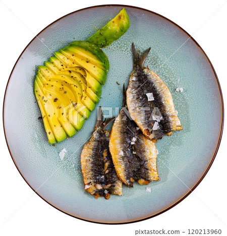 Delicious fried sardines with fresh avocado slices closeup Delicious fried sardines with fresh avocado slices closeup 120213960