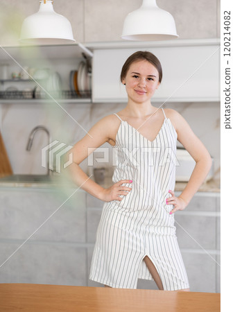 Young smiling girl posing against background of white kitchen 120214082