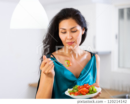 Portrait of asian woman eating salad at home 120214142