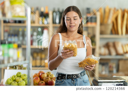 Young woman choosing corn flakes in grocery store 120214366