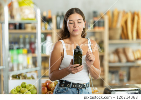 Young woman choosing olive oil in grocery store Young woman choosing olive oil in grocery store 120214368
