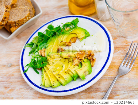 Avocado and cheese served with arugula and walnuts Avocado and cheese served with arugula and walnuts 120214665