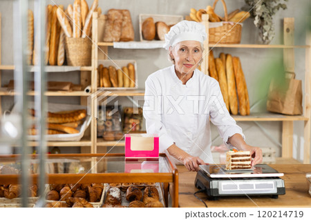 Elderly woman seller weighs piece of cake Elderly woman seller weighs piece of cake 120214719