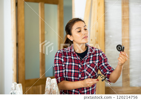 Woman assembling door handle 120214756