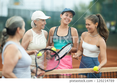 Group of women talking on tennis court Group of women talking on tennis court 120214789
