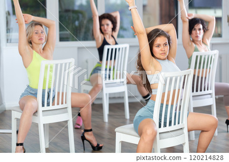 Sitting on chair, girl with long hair train to perform lap dance, interacting with imaginary partner Sitting on chair, girl with long hair train to perform lap dance, interacting with imaginary partner 120214828