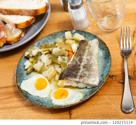 There is plate with fried cod fillet and stewed vegetable on wooden table. 120215114