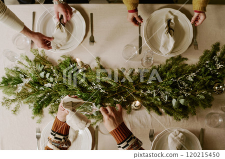 Top down shot of unrecognizable female and male hands polishing and serving table together to prepare for X-mas night Top down shot of unrecognizable female and male hands polishing and serving table together to prepare for X-mas night 120215450