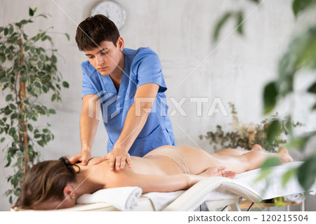 Massage by man in blue scrubs Massage by man in blue scrubs 120215504