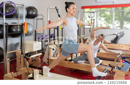 Young woman doing stretching on pilates machine 120215688