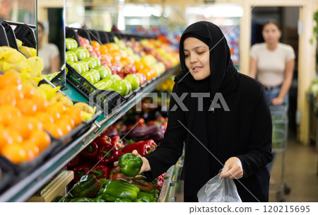 Young woman in hijab buys bell pepper at grocery store Young woman in hijab buys bell pepper at grocery store 120215695