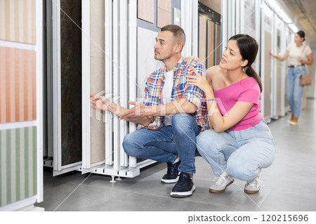 Married couple chooses floor tiles for their home together 120215696