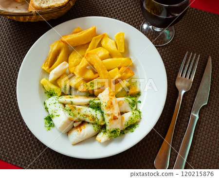 fried cuttlefish drizzled with white garlic and parsley sauce,lemon wedge and french fries on plate fried cuttlefish drizzled with white garlic and parsley sauce,lemon wedge and french fries on plate 120215876