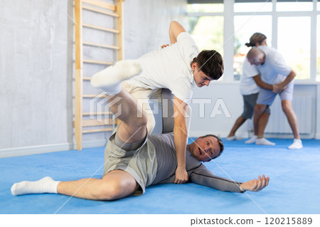 Two men training judo technique in studio 120215889