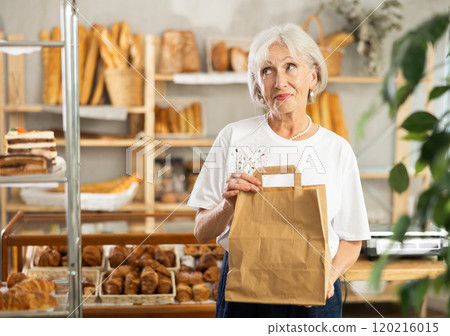 Portrait of an elderly woman with paper bag of fresh baked goods in bakery interior Portrait of an elderly woman with paper bag of fresh baked goods in bakery interior 120216015