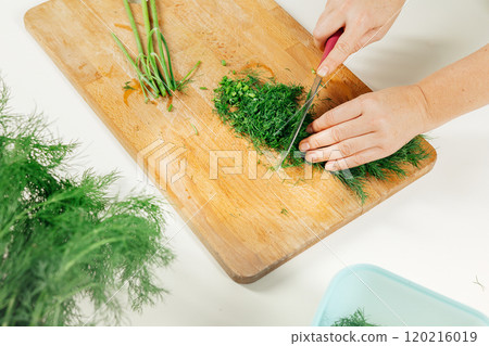 Fresh dill chopping on wooden board with knife for culinary preparation.Preparing dill for winter storage 120216019