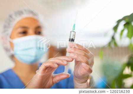 Closeup of syringe with medicine in hands of female doctor 120216230