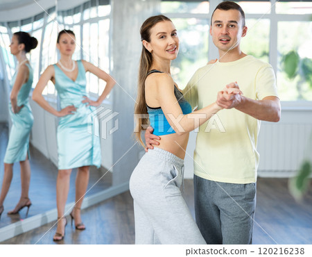 Smiling couple rehearsing wedding waltz in dance studio Smiling couple rehearsing wedding waltz in dance studio 120216238