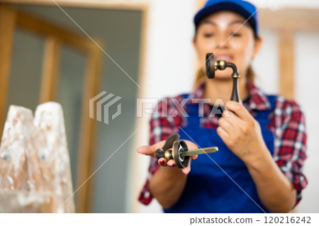 Woman builder demonstrates bronze door handles Woman builder demonstrates bronze door handles 120216242