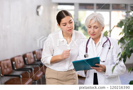 Experienced elderly female doctor consulting young woman Experienced elderly female doctor consulting young woman 120216390