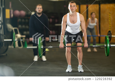 Man performing barbell deadlift during cross training at gym 120216392
